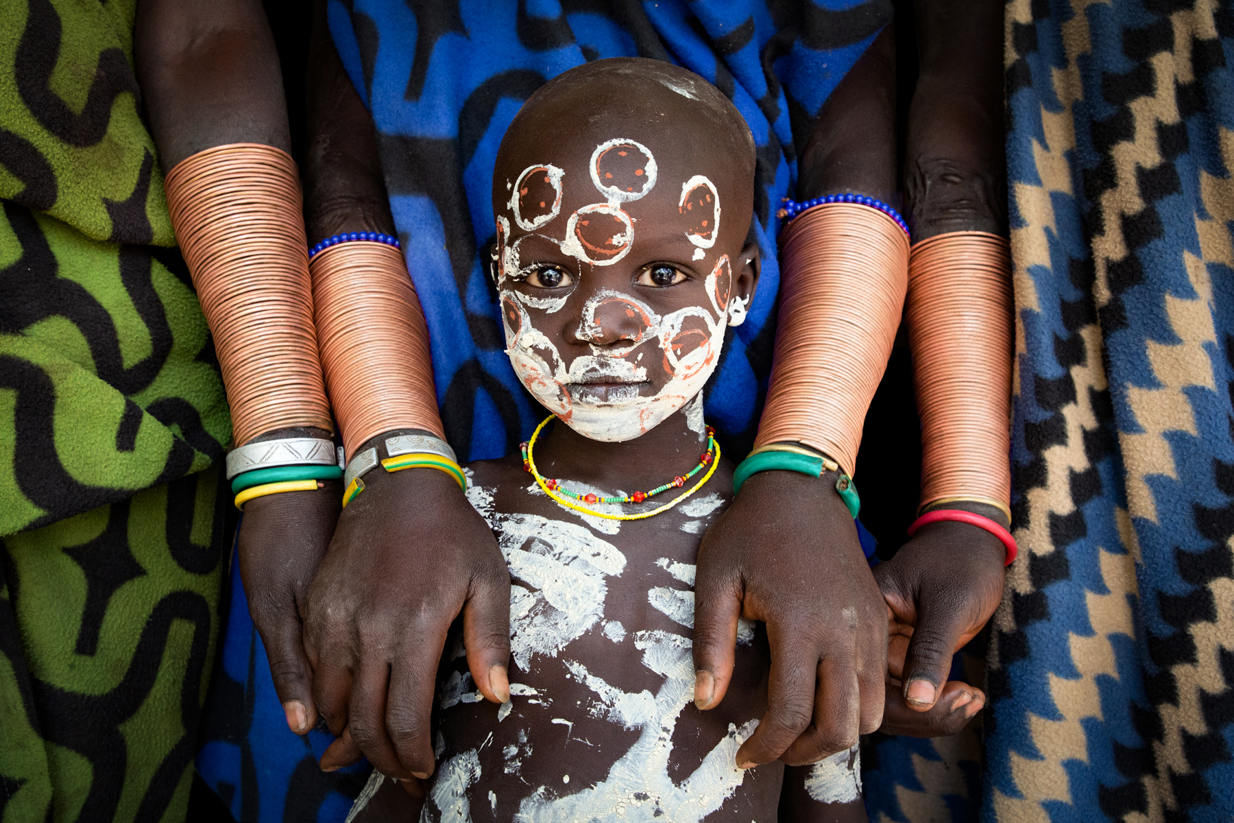 Portrait of Babuku with the women of his Suri tribe in southern Ethiopia