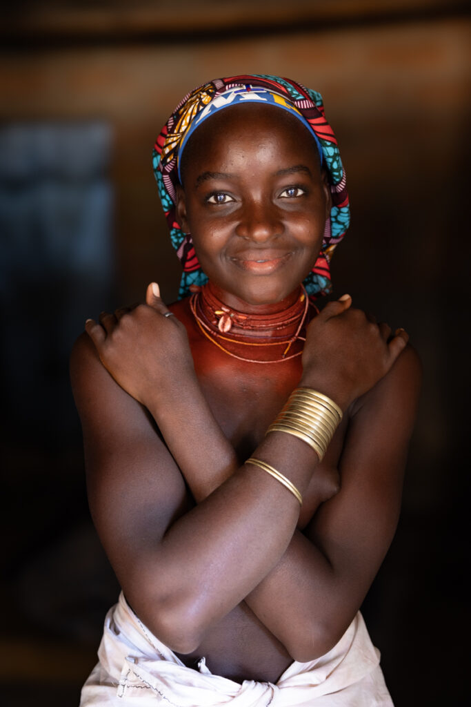 A beautiful young Ovakuvale woman. As a form of beautification Ovakuvale women rub ‘mupeque’ oil (reddish oil obtained from a crushed nut found in the desert) on their necks and bodies (image by Ingrid Koedood)