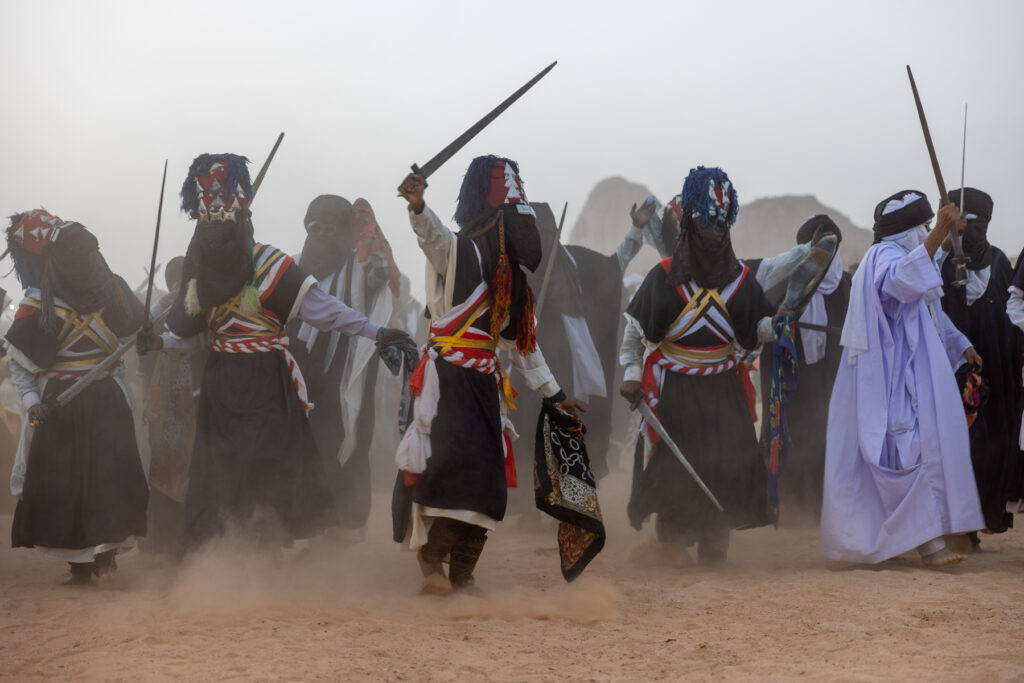 Tuareg men waving their Takuba swords in the air as they celebrate the ancient cultural Sebiba festival in Djanet (image by Ingrid Koedood)