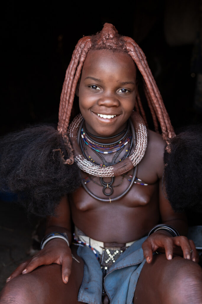 An adorable young girl from the Ovatwa people, posing inside a modest home (image by Ingrid Koedood)