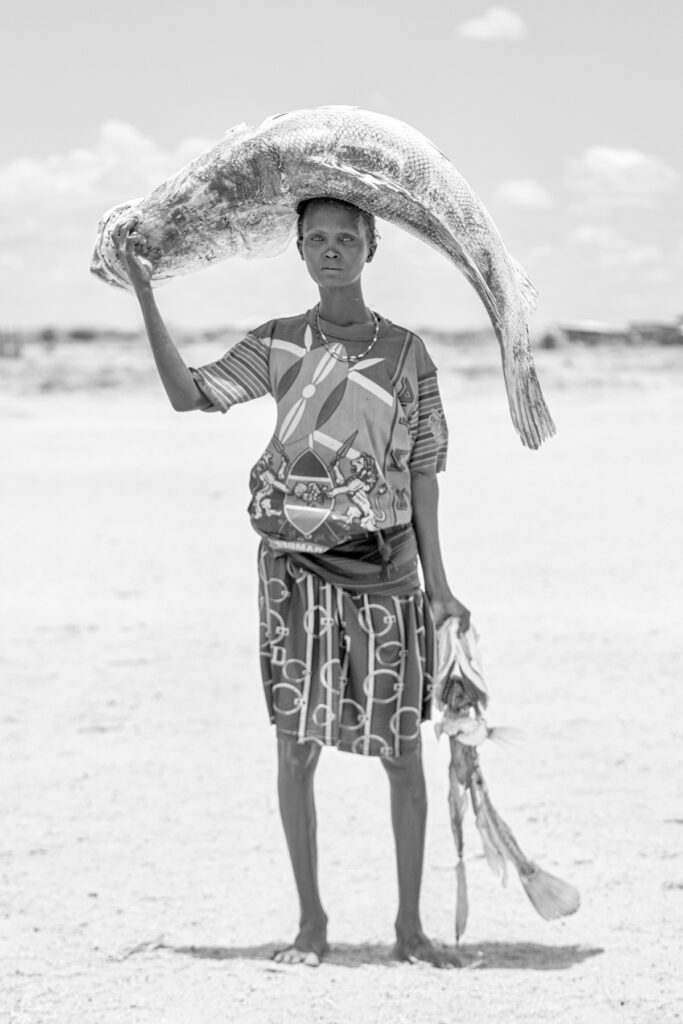 A Diyes woman transporting a fish and a giant Nile Perch back to her home (image by Inger Vandyke)