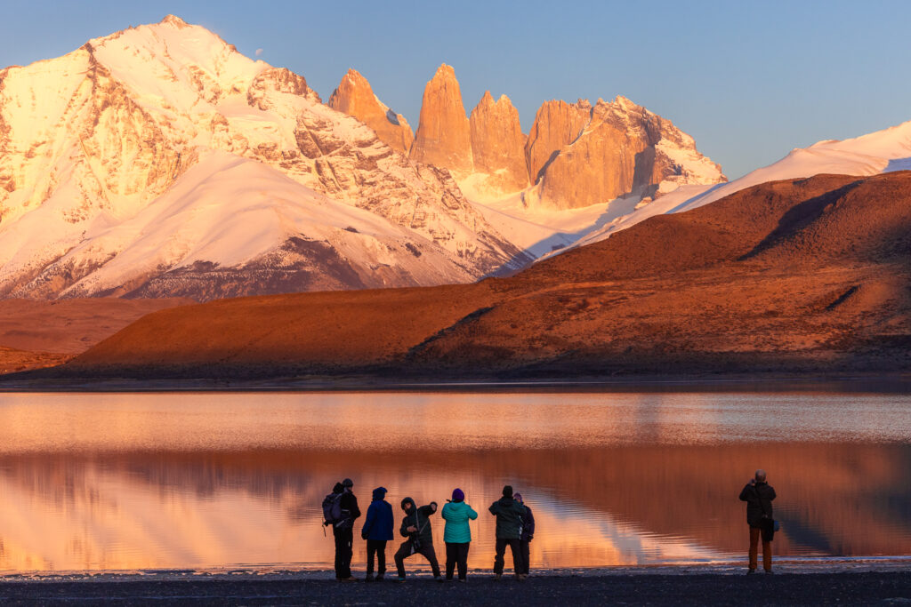 This year's clients marvel at the Paine Massif, reflected in Laguna Amarga, while co-guide Mauricio larks about (image by Gin Wilde)