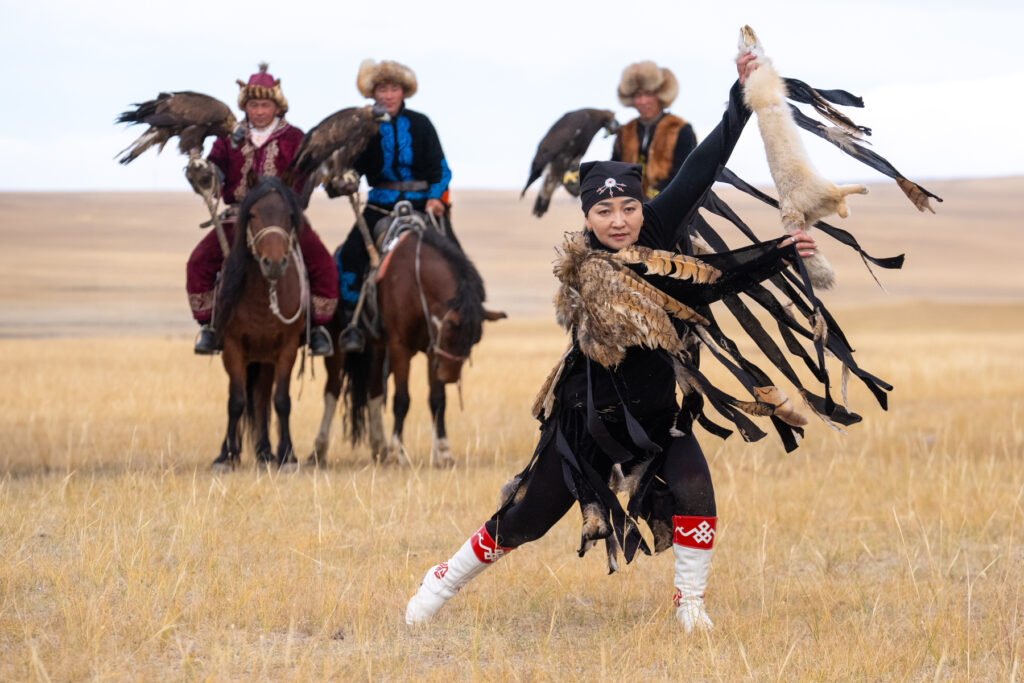 A young Kazakh woman dancing to open the annual Eagle Hunter Festival at Tolbo Lake (image by Inger Vandyke)